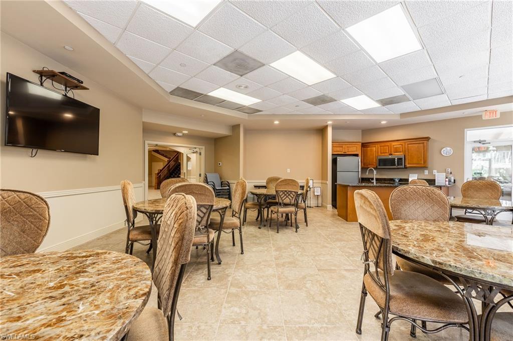 Dining room with baseboards, light tile patterned floors, and a paneled ceiling