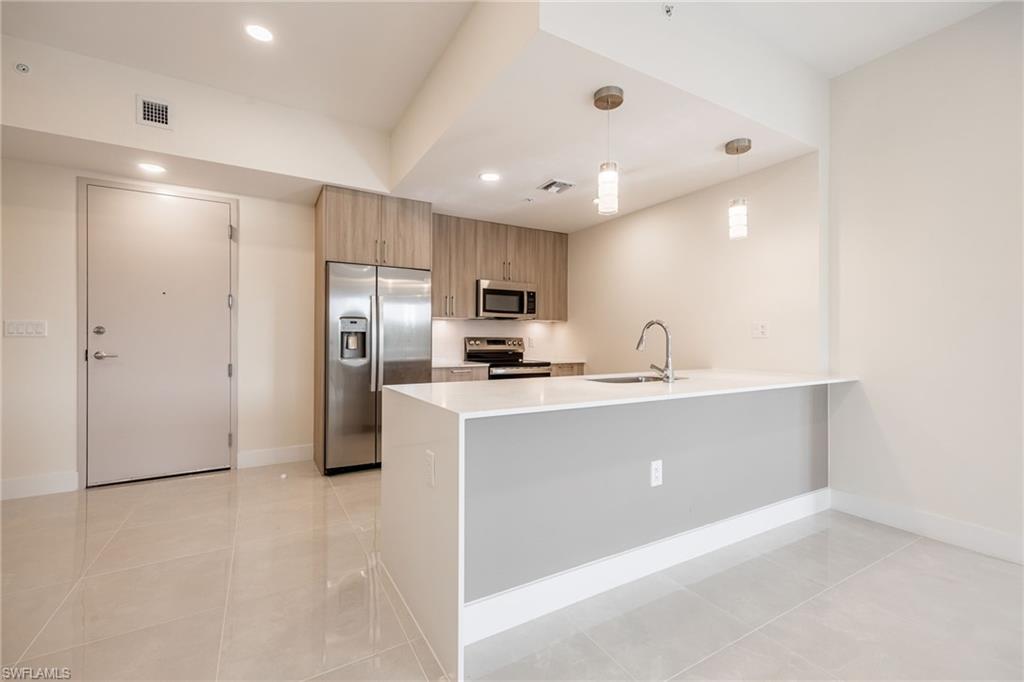 Kitchen featuring a peninsula, visible vents, a sink, and appliances with stainless steel finishes