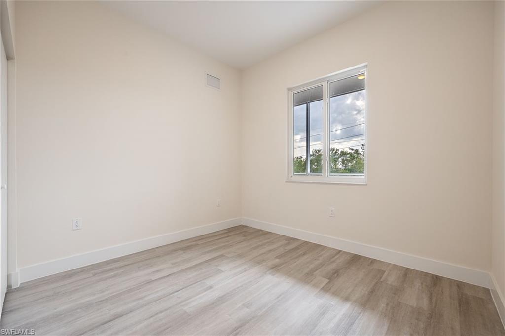 Spare room with visible vents, light wood finished floors, and baseboards