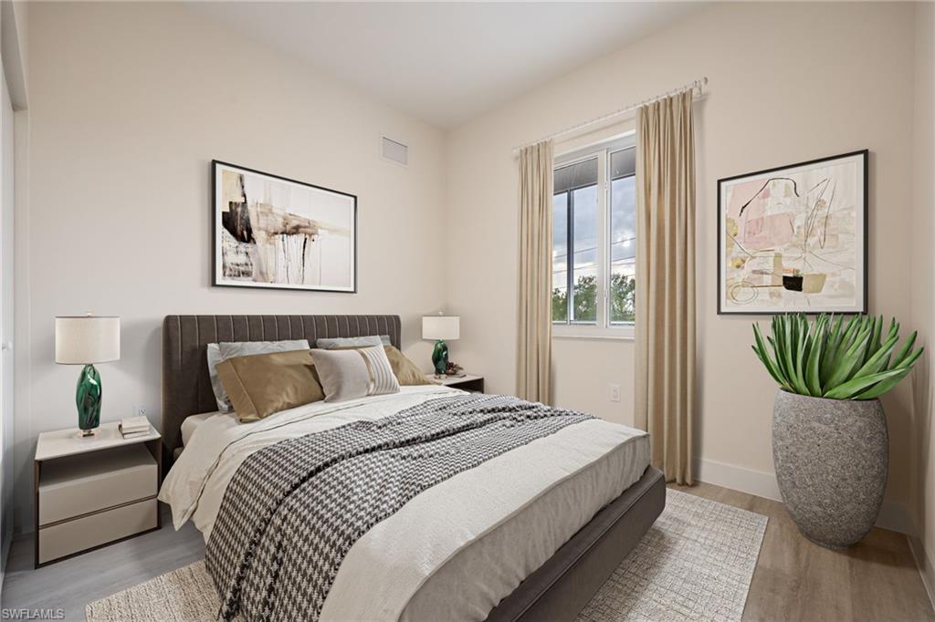 Bedroom with wood finished floors, visible vents, and baseboards