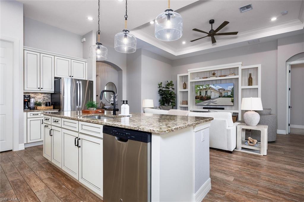 Open-concept living space with a kitchen island featuring a granite countertop and integrated stainless steel dishwasher