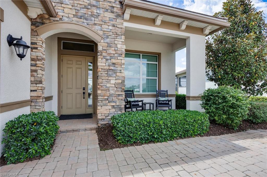 Stone veneer and stucco exterior with an arched entryway