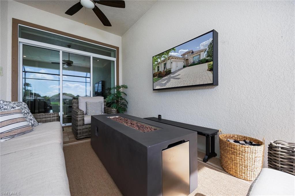Covered outdoor lanai with textured walls, ceiling fan, and sliding glass doors