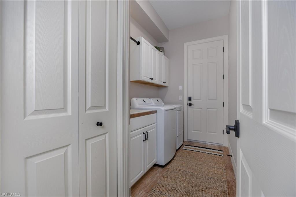 Laundry area featuring white cabinetry, wood-finish countertop, and a light wood-finish flooring