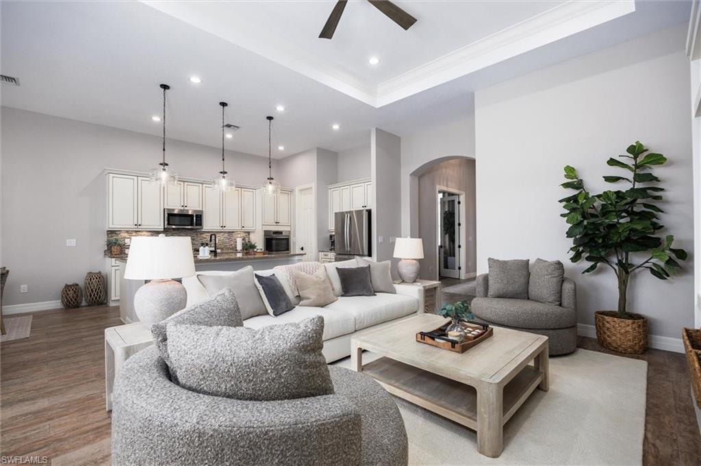 Open-concept living area featuring high tray ceilings and recessed lighting