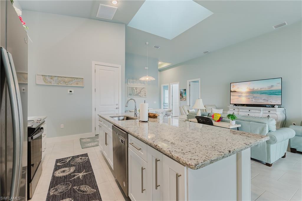 Kitchen island featuring a granite countertop, undermount sink, and integrated dishwasher