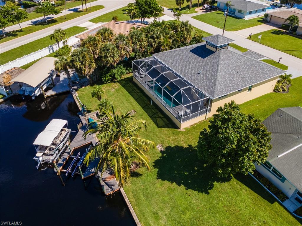 Waterfront property featuring a screened-in pool, boat dock, and covered boat lift