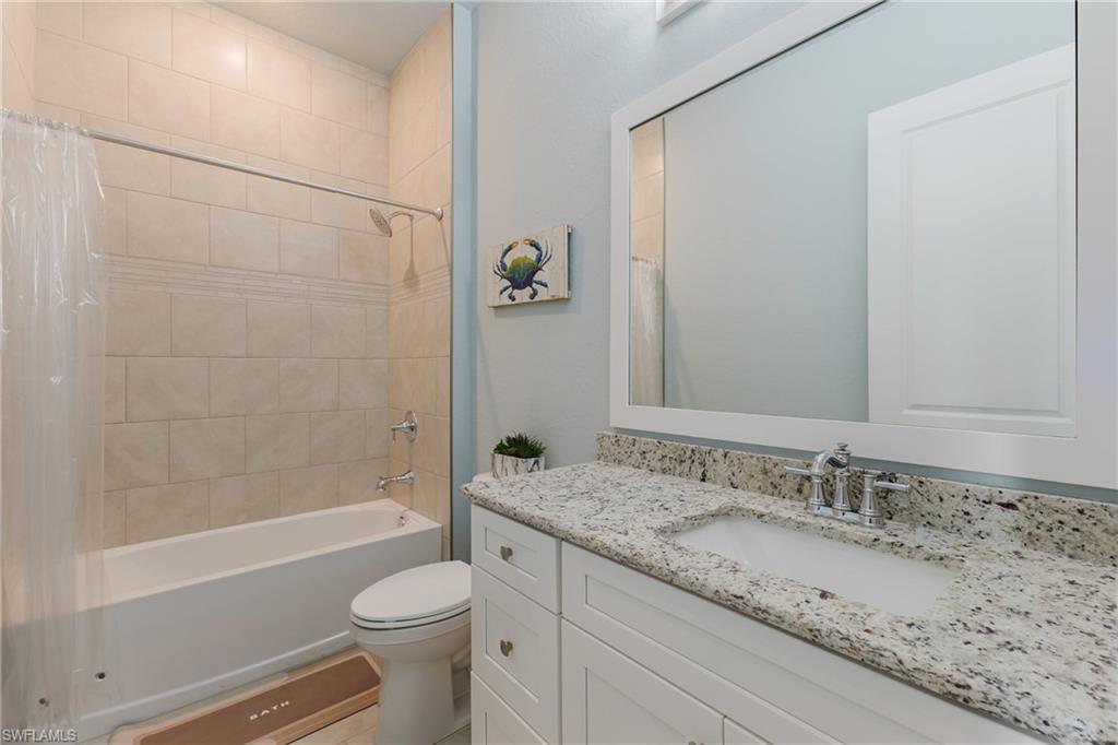 Bathroom featuring a white vanity with a light-toned granite countertop, an undermount sink, and chrome fixtures