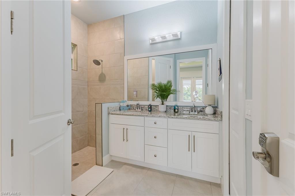Bathroom featuring a dual vanity with white cabinetry and a speckled countertop
