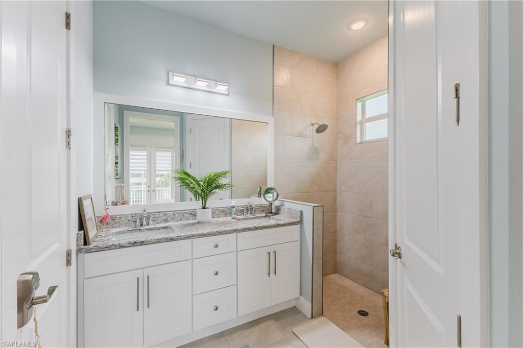Spacious bathroom featuring a double vanity with granite countertops and white cabinetry