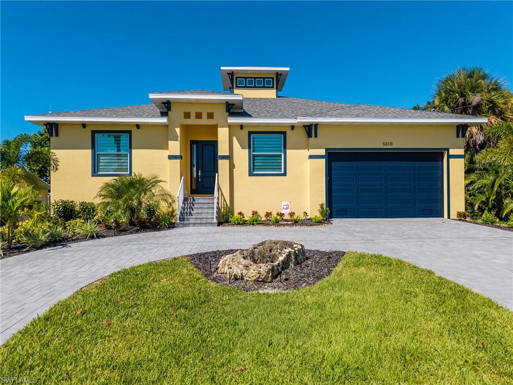 Contemporary residence featuring a yellow exterior with dark trim accents and a contrasting dark garage door