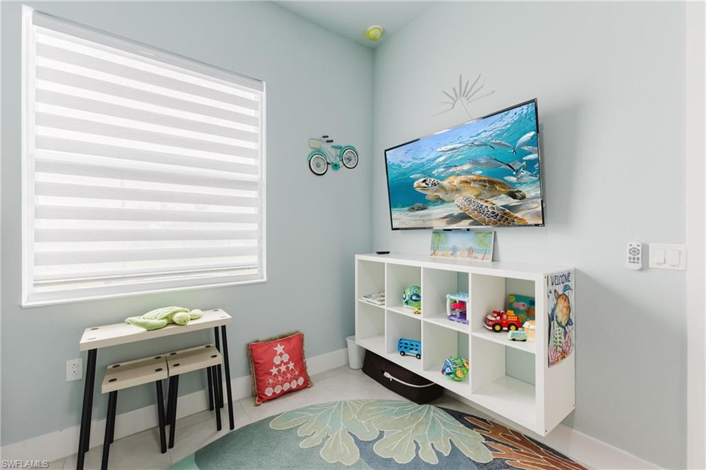 Light blue painted wall with a wall-mounted television and built-in white shelving unit