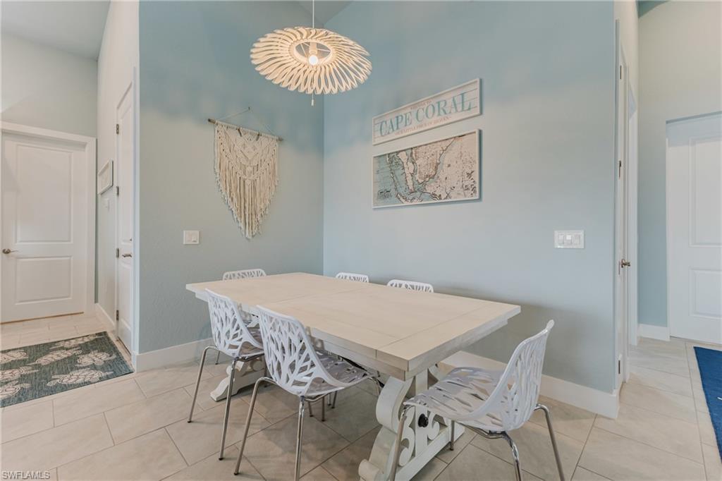 Dining area featuring light blue walls, a light-toned dining table, and tile flooring