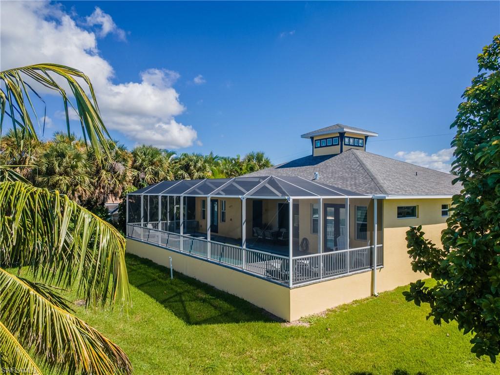 Exterior showcasing a screened-in lanai, a distinctive cupola, and a shingled roof