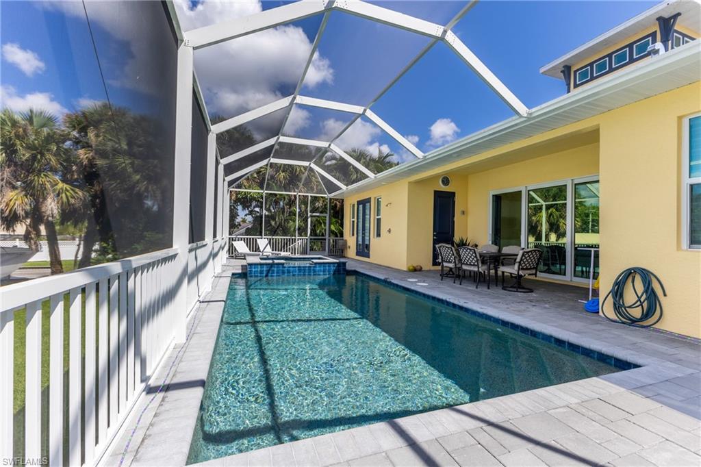 Screened outdoor living area featuring a rectangular pool with integrated spa