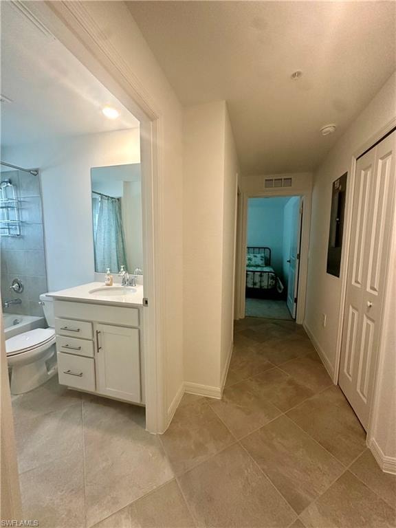 Full bath featuring tile patterned flooring, vanity, toilet, tub / shower combination, and baseboards