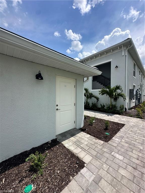 View of exterior entry with stucco siding