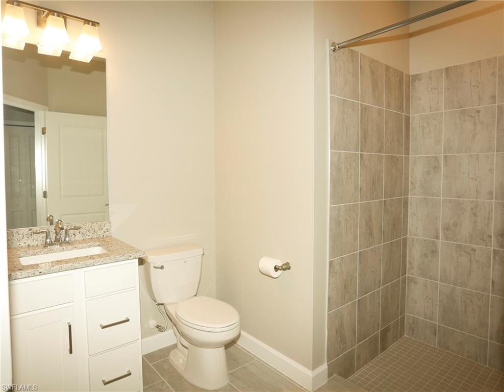 Bathroom featuring a white vanity with a speckled countertop, undermount sink, and brushed nickel faucet