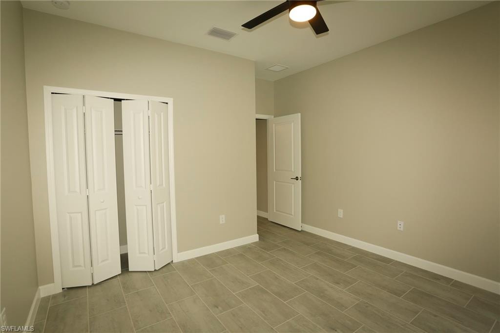 Interior room featuring light-colored walls, contemporary tiled flooring, and a ceiling fan with integrated lighting