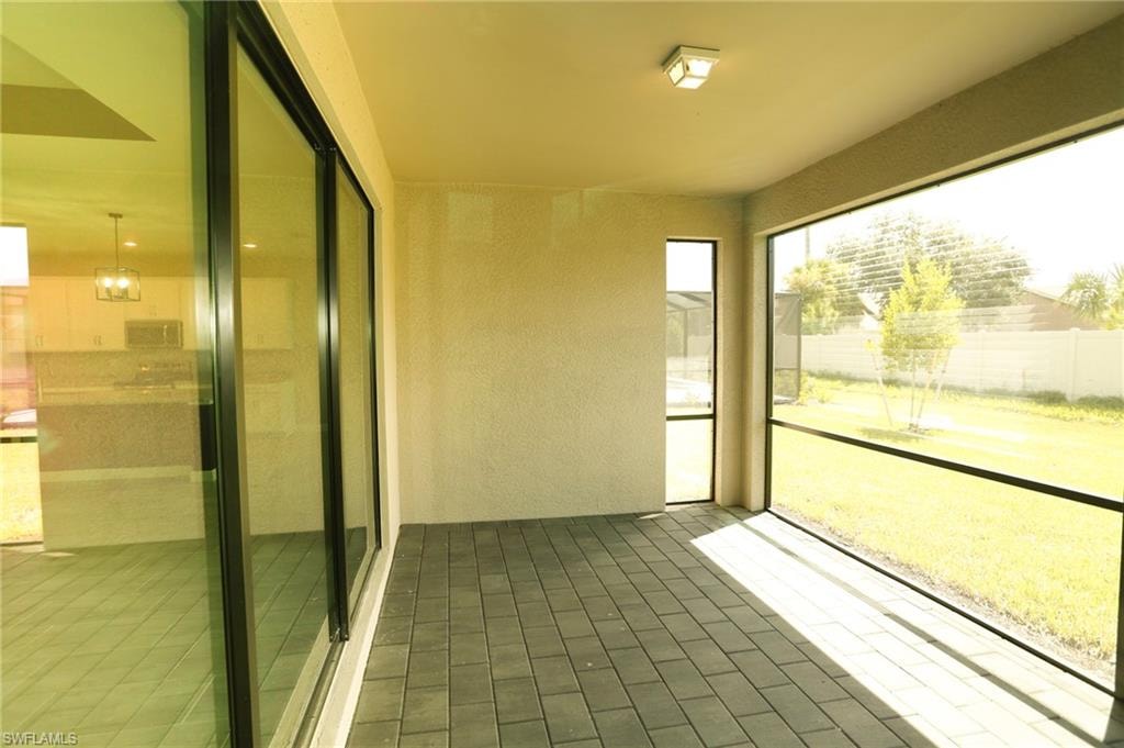 Screened patio featuring paver flooring, stucco walls, and a recessed ceiling light