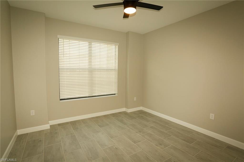 Room featuring wood-finish tile flooring, neutral wall paint, and white baseboards