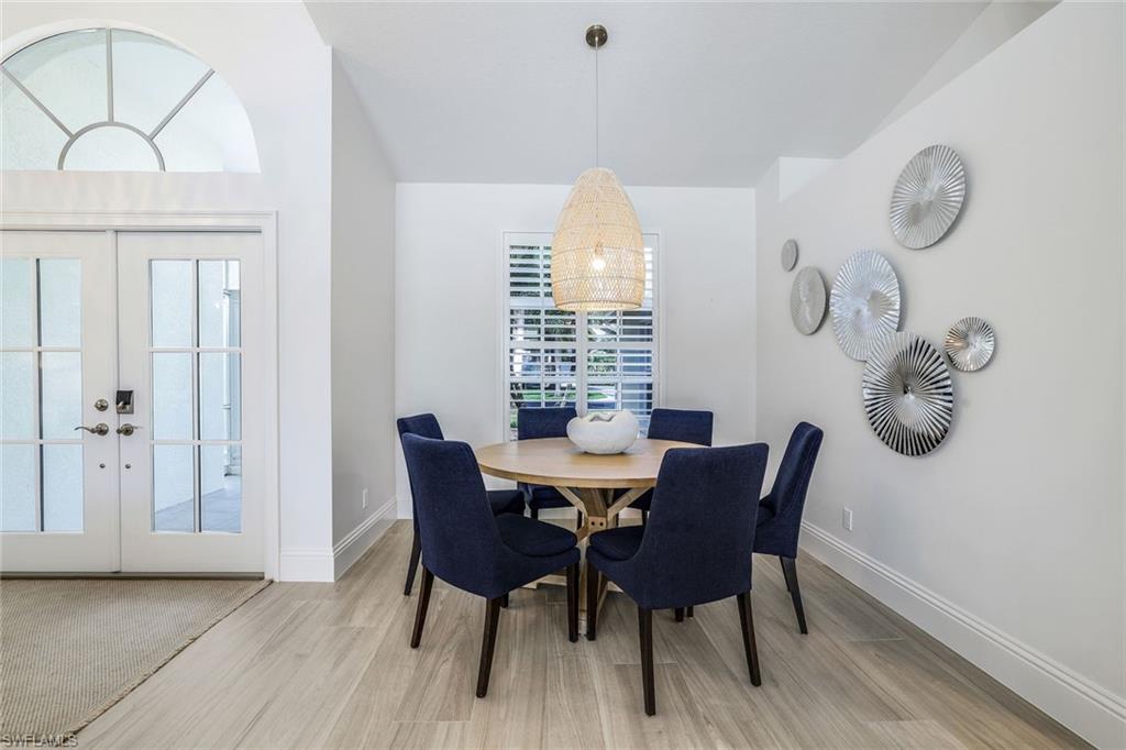 Dining area with light hardwood / wood-style floors, french doors, and lofted ceiling