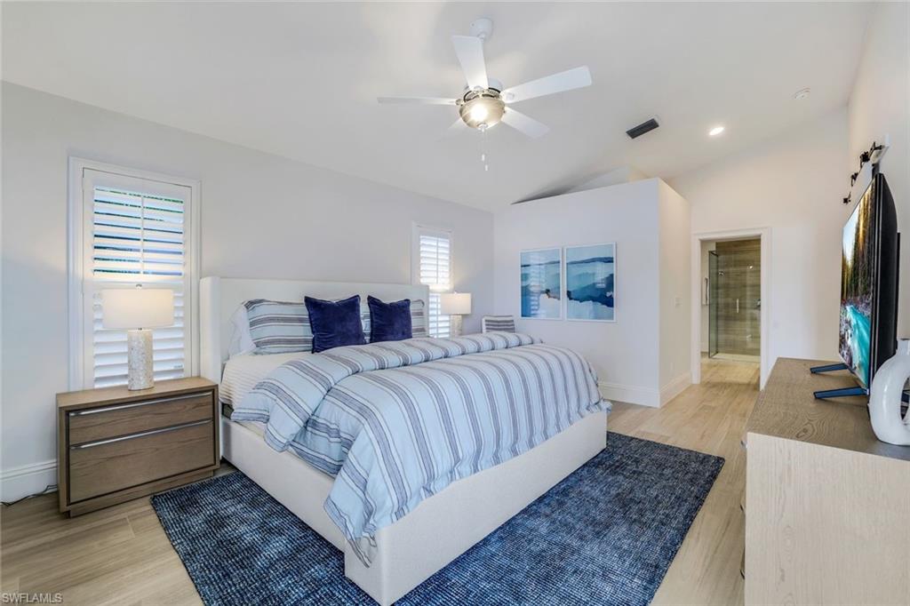 Bedroom with multiple windows, light hardwood / wood-style floors, lofted ceiling, and ceiling fan