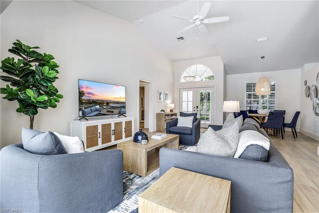 Living room featuring high vaulted ceiling, wood-type flooring, ceiling fan, and french doors