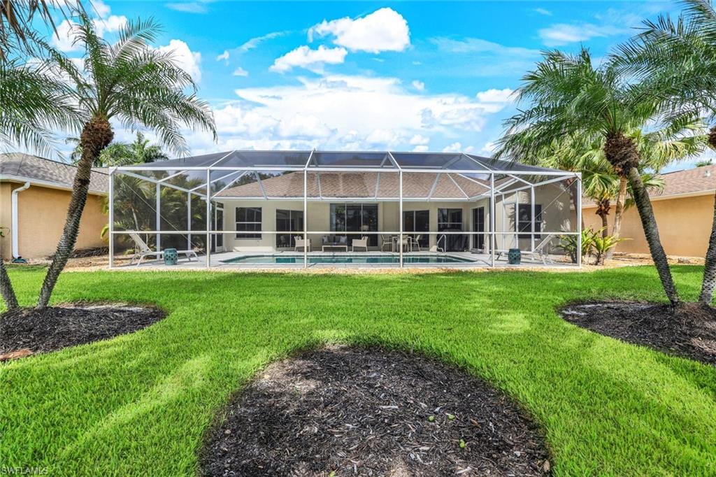 Back of property with a lanai and a yard
