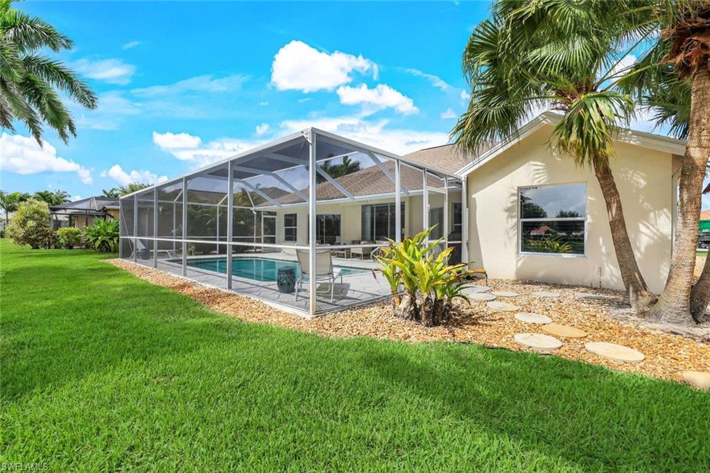 Back of house featuring a lawn, a lanai, and a patio