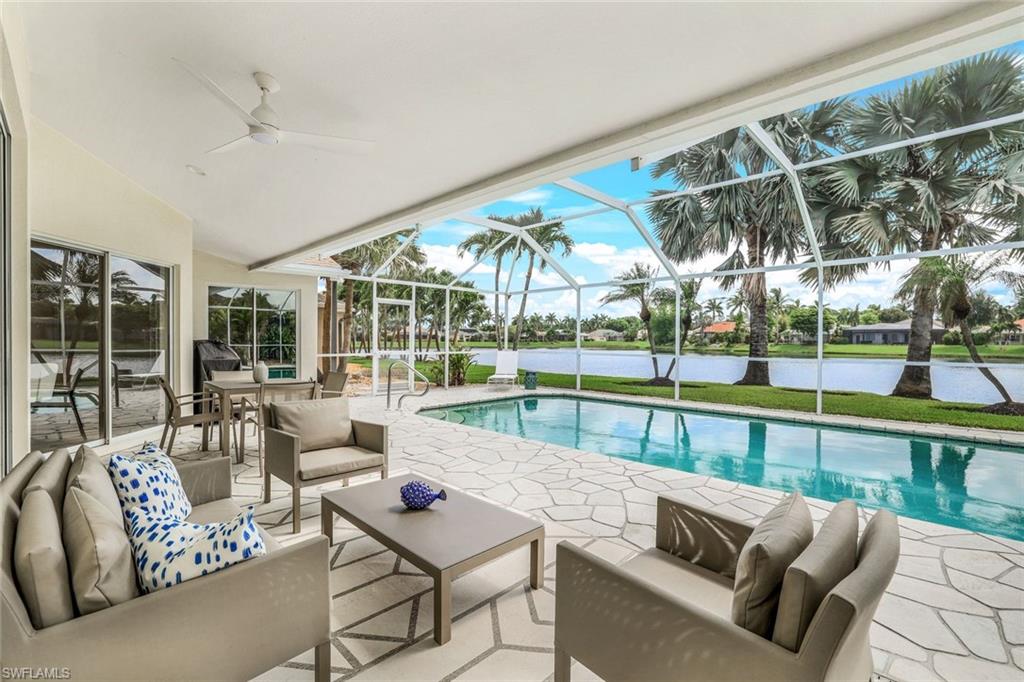 View of swimming pool with a patio area, an outdoor hangout area, a water view, glass enclosure, and ceiling fan