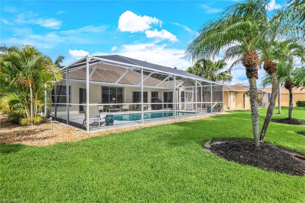 Rear view of property featuring a patio, a lanai, and a yard