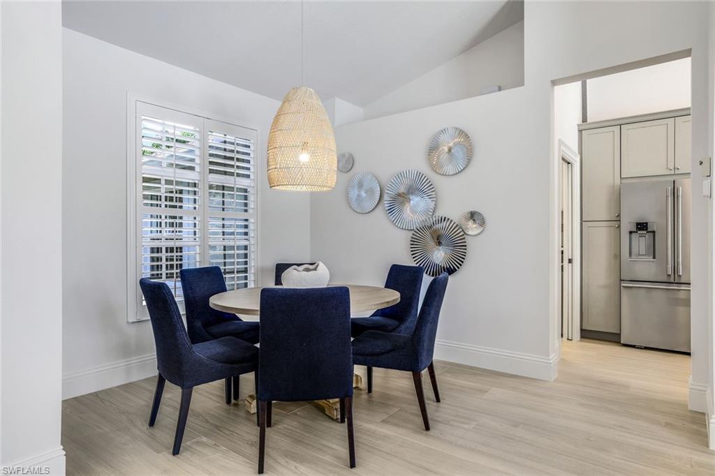 Dining room with vaulted ceiling and light hardwood / wood-style floors