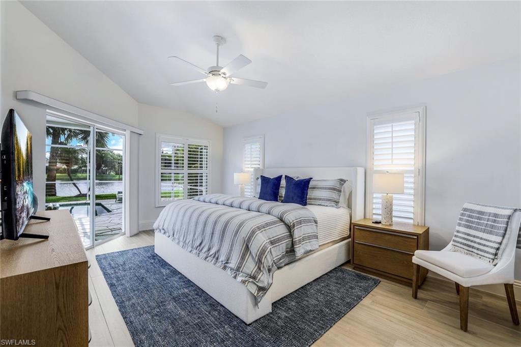 Bedroom featuring ceiling fan, light hardwood / wood-style flooring, access to exterior, and lofted ceiling