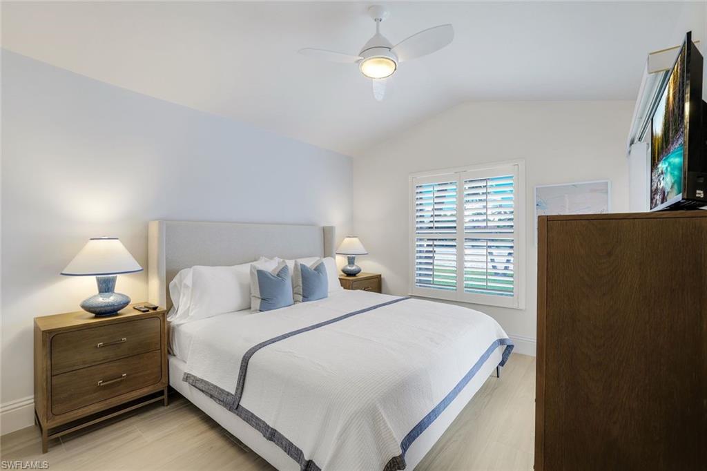 Bedroom with lofted ceiling, light wood-type flooring, and ceiling fan