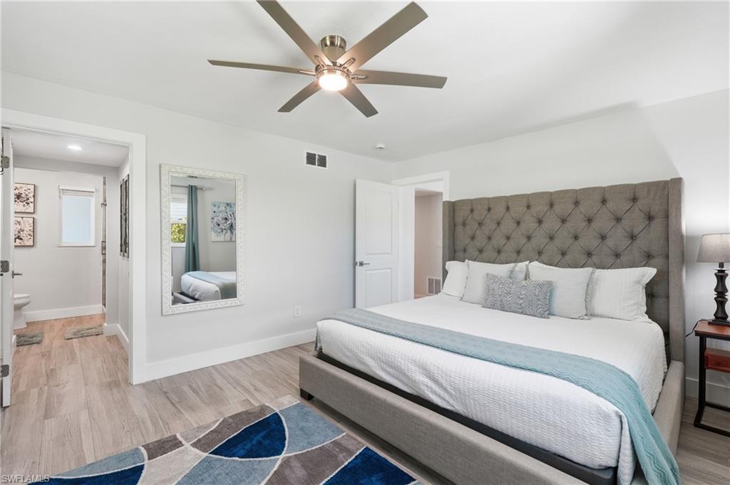 Interior bedroom featuring wood-finish flooring and light-toned walls - Virtually Edited Image