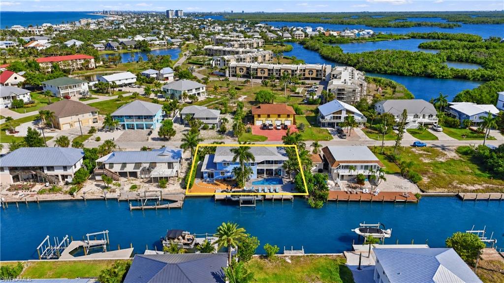 Waterfront property featuring a private boat dock, in-ground swimming pool, and an elevated deck - Virtually Edited Image