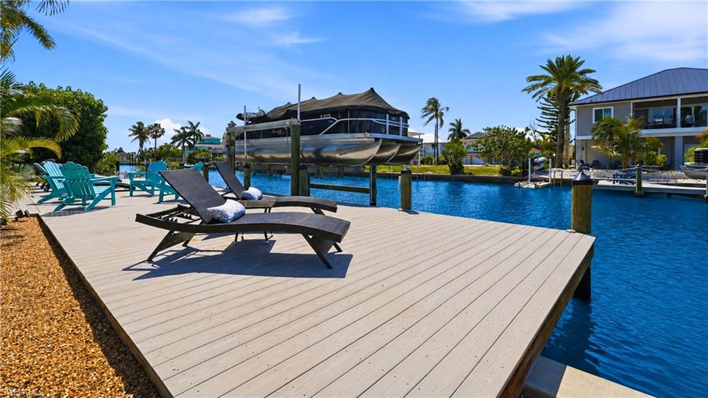 Waterfront dock featuring composite decking, direct canal access, and an integrated boat lift - Virtually Edited Image