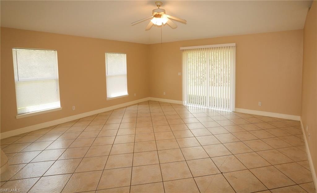 Spacious room featuring neutral-toned walls, tile flooring, and a ceiling fan
