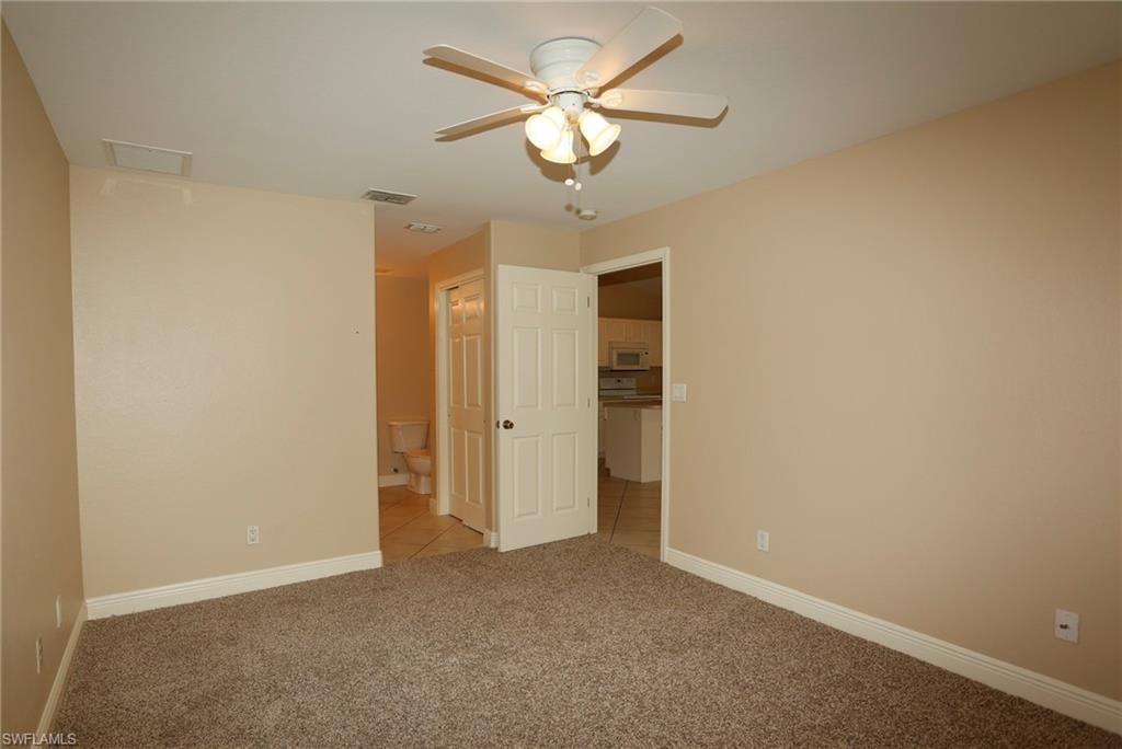 Carpeted room with neutral tone walls and white baseboards