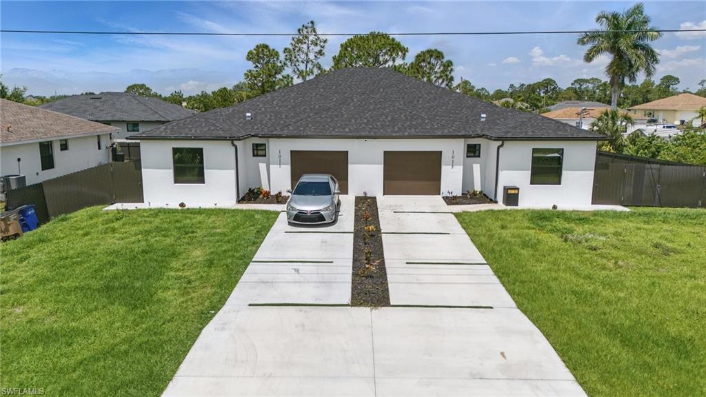 View of front of house featuring driveway, stucco siding, an attached garage, and a shingled roof