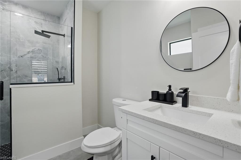 Full bath with toilet, a shower stall, and vanity