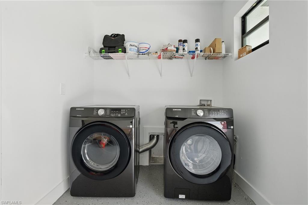 Washroom featuring washer and dryer and baseboards