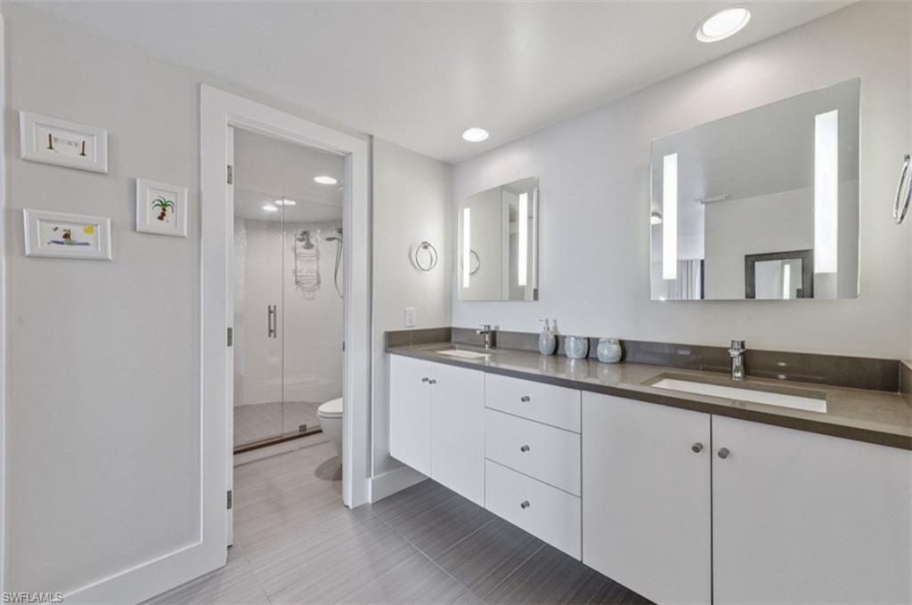 Full Bathroom featuring double vanity, a stall shower, and recessed lighting