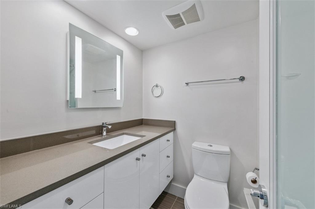Full Bathroom with light up vanity and glass shower door