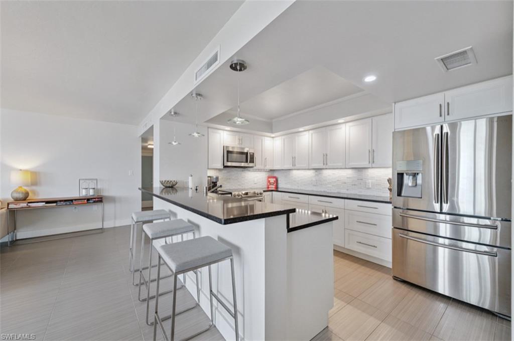 Kitchen with stainless steel refrigerator with ice dispenser