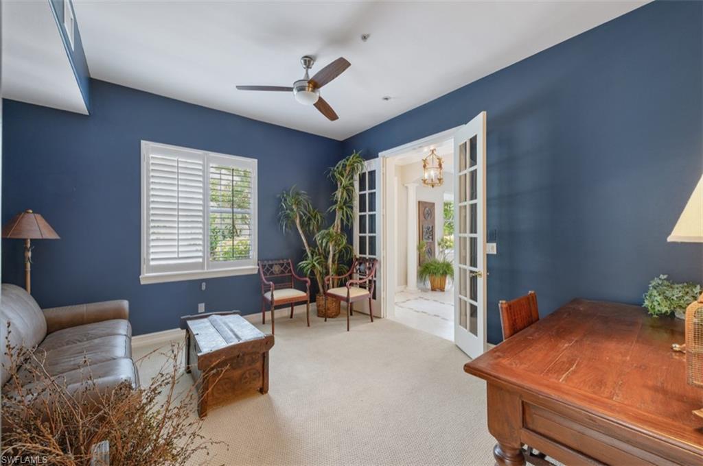 Carpeted Den with ceiling fan