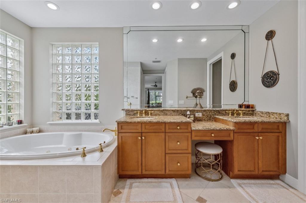 Master Full Bathroom featuring double vanity, a jetted tub, and tile patterned floors