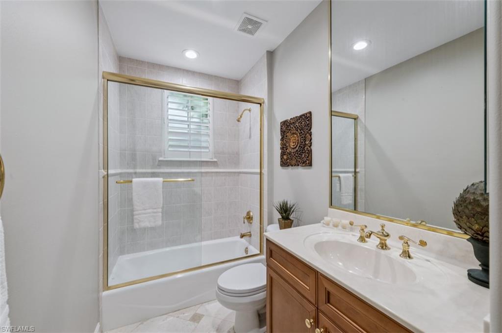 Full Bathroom featuring vanity and bath / shower combo with glass door