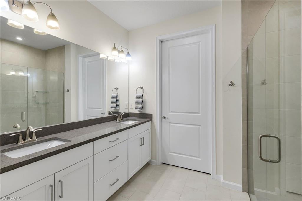 Master bathroom with quartz counters and frameless shower.